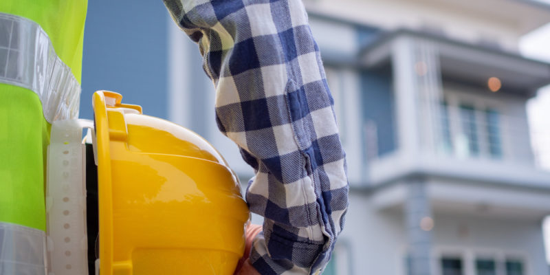 Male contractor is looking at the house project area that has been assigned to do. Check the preparation of the house before sending it to the homeowner .